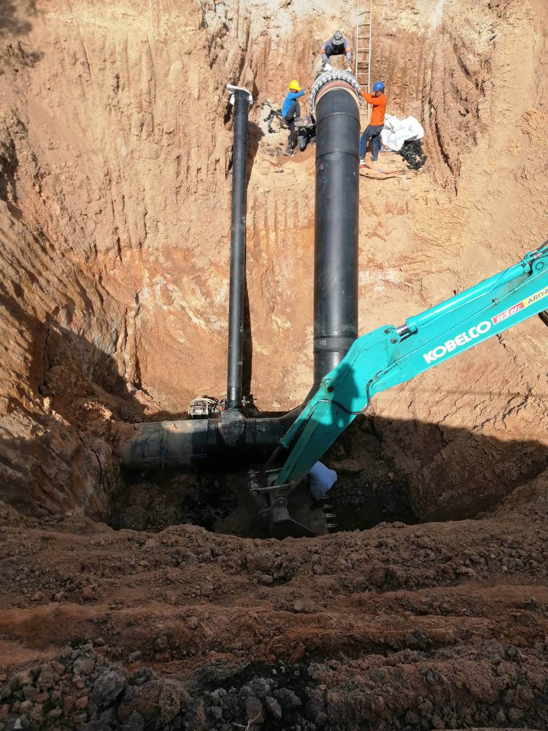 Backhoe machine excavating the ground for the installation of underground pipes