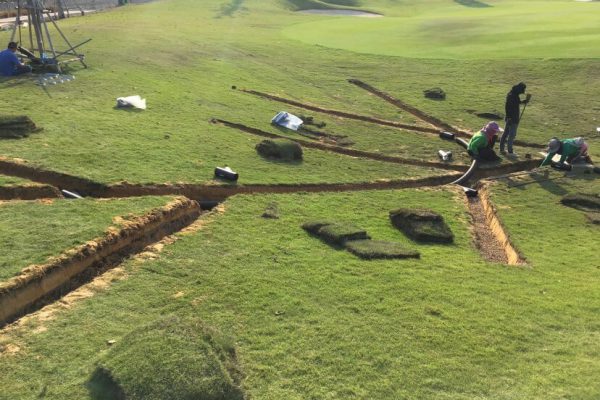 Engineer installing corrugated pipes in a golf course