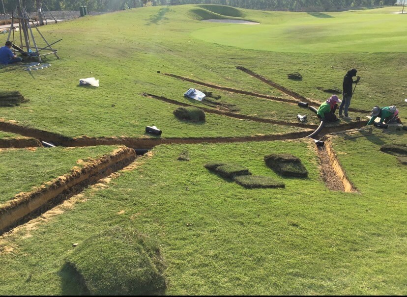 Engineer installing corrugated pipes in a golf course