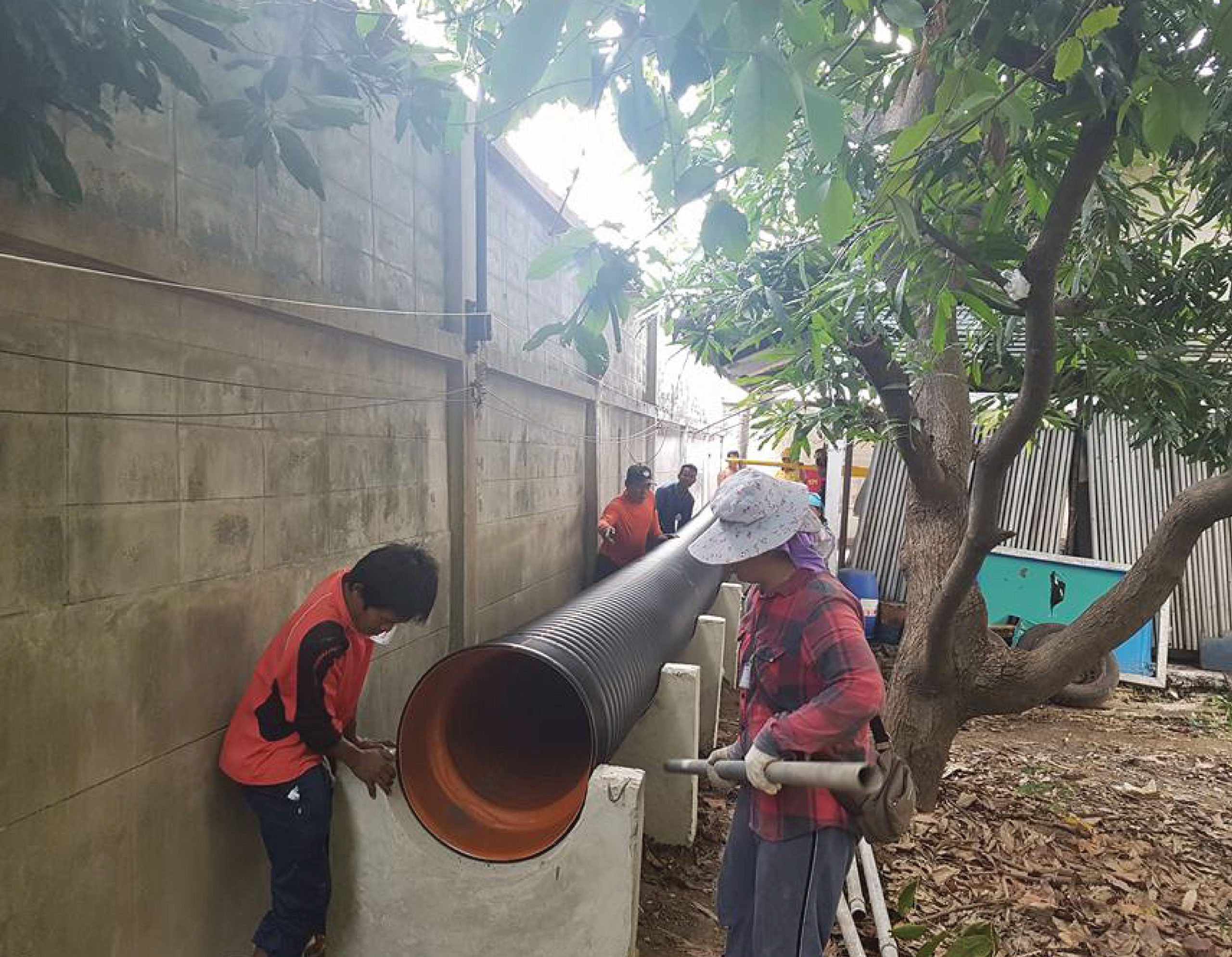 Engineer installing TAPKORR pipe on concrete support.