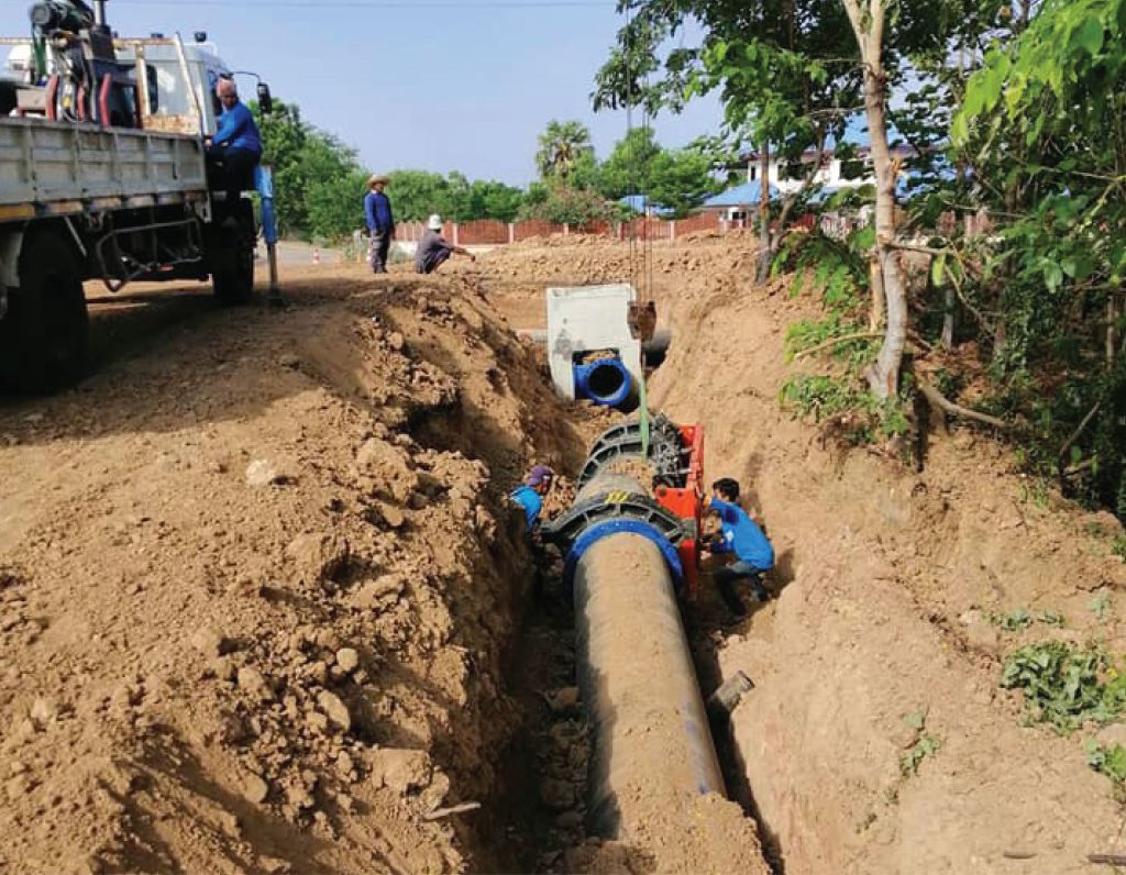 Engineer inspecting HDPE pipe welds in a trench at Buriram province