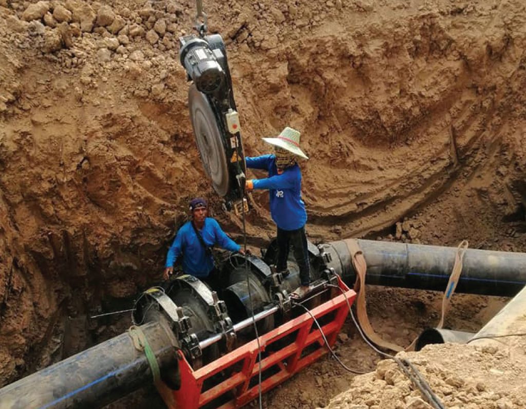 Engineers install a heating pad for butt-fusion welding of HDPE pipes in a drought relief project in Buriram province