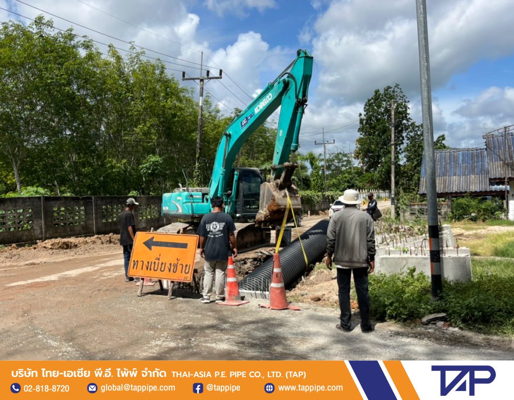 Technician controls the placement of deep trench corrugated pipes in water pipe work